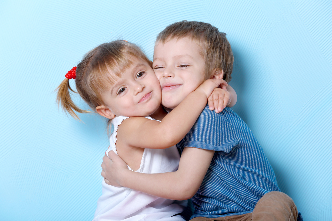 Children Hugging on Blue Background